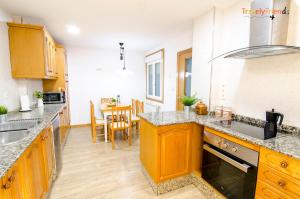 a kitchen with wooden cabinets and a dining room at GS Superb apartment with public garage in Santiago de Compostela