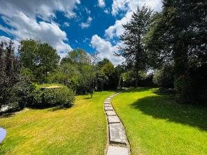 un sentiero attraverso un parco con erba e alberi verdi di Villa Ledezma a Villa del Carbón