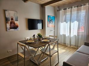Moda Apartments 69 في سيستريير: غرفة طعام مع طاولة مع كراسي وتلفزيون