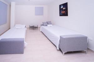 a hotel room with two beds and a table at Hotel porto escondido in Santa Bárbara de Samaná