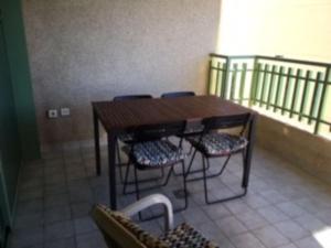uma mesa de madeira e cadeiras num quarto em Apartamento frente al mar en Playa Patacona em Valência