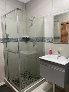 a bathroom with a shower and a sink at The Timeless Way Self Catering Accommodation in Swakopmund