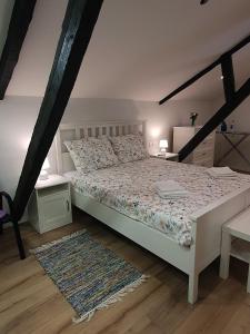 1 dormitorio con cama blanca y alfombra en Kuća za odmor Žinžula, en Medulin