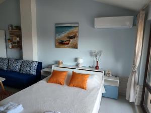 um quarto com uma cama com almofadas laranja em Studio Senso di Mare em Sozopol