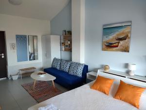 a living room with a bed and a blue couch at Studio Senso di Mare in Sozopol