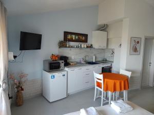 a small kitchen with a table and a microwave at Studio Senso di Mare in Sozopol