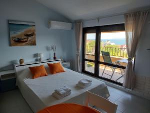 a bedroom with a bed with a view of a balcony at Studio Senso di Mare in Sozopol