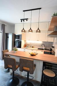 a kitchen with a large wooden island with bar chairs at Apartment Mina Dream in Jelsa