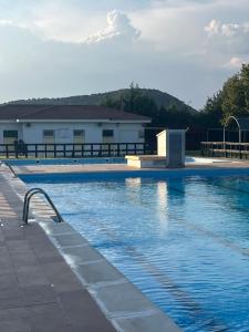 a swimming pool with blue water in front of a building at ALOJAMIENTO LOS DINOSAURIOS in Cuenca