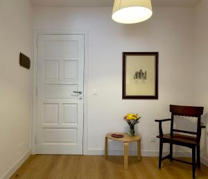 サンタ・クルス・デ・ラ・パルマにあるCasa La Quinta Verdeの白いドア、椅子、テーブルが備わる客室です。