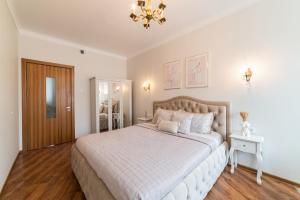 een slaapkamer met een groot bed en een kroonluchter bij E. D. Angel Wing Apartment in Šiauliai
