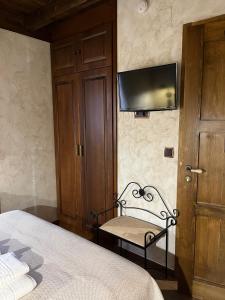 a bedroom with a bed and a television on the wall at La CasuKa VUT Fabero in Fabero