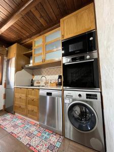 a kitchen with a washing machine and a microwave at La CasuKa VUT Fabero in Fabero