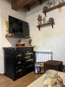 a black dresser with a television on top of it at La CasuKa VUT Fabero in Fabero