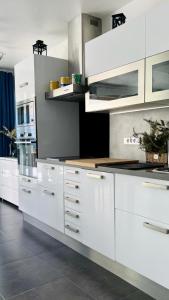 une cuisine avec des armoires blanches et un comptoir dans l'établissement VUE MER IMPRENABLE ET PISCINE, à Bandol