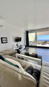 una sala de estar con 2 sofás y una ventana grande en VUE MER IMPRENABLE ET PISCINE, en Bandol