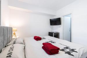 Un dormitorio con una cama con toallas rojas. en Feel Home Sea View, en Bat Yam
