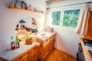 eine Küche mit einer Theke mit einem Waschbecken und einem Fenster in der Unterkunft Casa Nonna in Lenzerheide