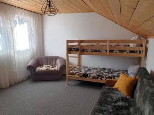 a living room with bunk beds and a couch at Cosy wooden house in the heart of Apuseni. in Beliş