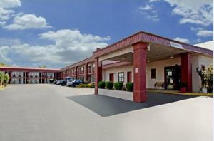 a large building with cars parked in a parking lot at Rodeway Inn in Canton