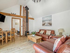 uma sala de estar com um sofá e uma mesa em Little Tree Cottage em Felmingham