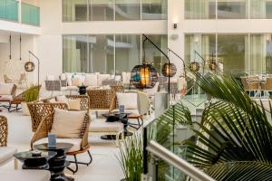a lobby with chairs and tables in a building at NissiBlu Beach Resort in Ayia Napa