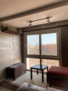 - un salon avec une grande fenêtre et un canapé dans l'établissement Cozy studio Porto golf, à El Alamein