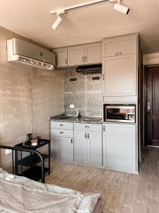 a kitchen with white cabinets and a table at Cozy studio Porto golf in El Alamein