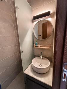 a bathroom with a sink and a mirror at Cozy studio Porto golf in El Alamein