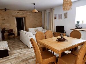 a living room with a table and a couch at Gîte La Petite Longère in Septfonds