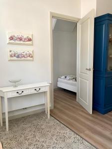 Habitación con mesa blanca y armario azul. en Basic Little House Scheveningen en Scheveningen