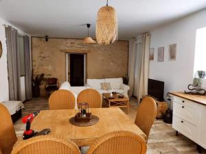 a living room with a wooden table and chairs at Gîte La Petite Longère in Septfonds