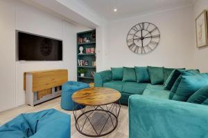 a living room with a green couch and a table at Bright and Cosy house with 3 bedroom 3 bathrooms in Bournemouth