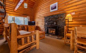 a living room with a fireplace in a log cabin at Cooper Spur Mountain Resort in Mount Hood