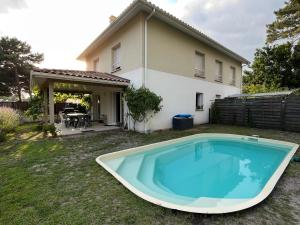 une grande piscine en face d'une maison dans l'établissement La cazalaise, à La Teste-de-Buch