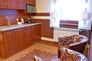 uma cozinha com armários de madeira, um lavatório e uma cadeira em Willa Parzenica em Bukowina Tatrzańska