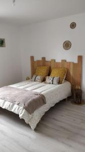 a bedroom with a large bed with a wooden headboard at Gîte le relais du Mardelon in Messemé