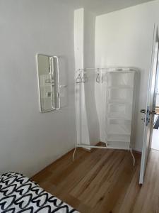 Apartment in Gmunden في غموندين: غرفة نوم مع مرآة وسرير وأرضية خشبية