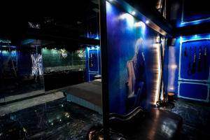 グダニスクにあるGrey Aqua Secret Apartamentの壁に青い照明と鏡が付いた部屋
