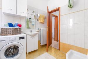 a bathroom with a washing machine and a sink at Mala Harmonija in Vodnjan