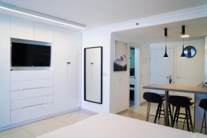 a bedroom with white walls and a table and chairs at Beachfront Boutique Apartment in Herzliya