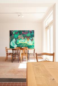een eetkamer met een tafel en stoelen en een schilderij bij Le Charbonnage in Genk