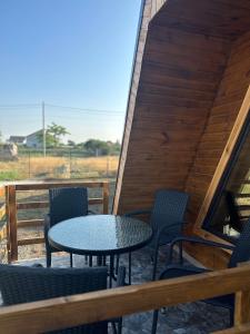 eine Terrasse mit einem Tisch und Stühlen auf einer Terrasse in der Unterkunft Casa de lemn 2,Tip A in Corbu