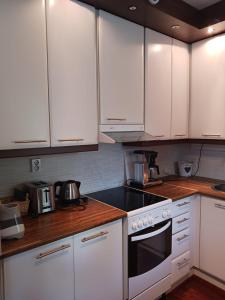 a kitchen with white cabinets and a stove top oven at Mukkula Vanhatie in Lahti