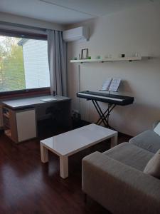 a living room with a keyboard and a couch at Mukkula Vanhatie in Lahti