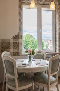 een tafel met stoelen en een vaas met bloemen erop bij E. D. Angel Wing Apartment in Šiauliai