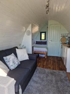 uma sala de estar com um sofá e uma cama em Jerusalem Farm Pods em Tranent