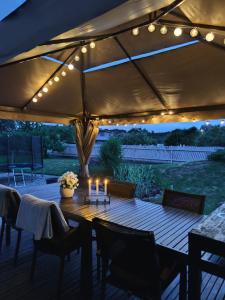 a patio with a wooden table with candles and lights at Arte Golf Apartment in Kuressaare