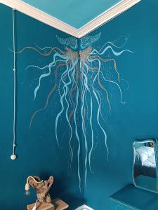 a wall mural of an octopus on a blue wall at Avó da Rosa 2 in Faial da Terra