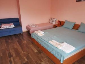 a room with two twin beds and a couch at Guest House Plamena in Krapets